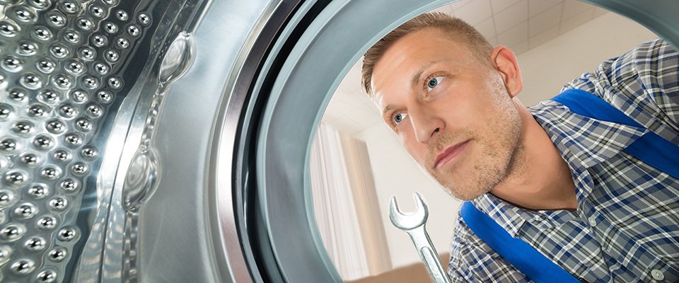Technician inspecting front-load washing machine