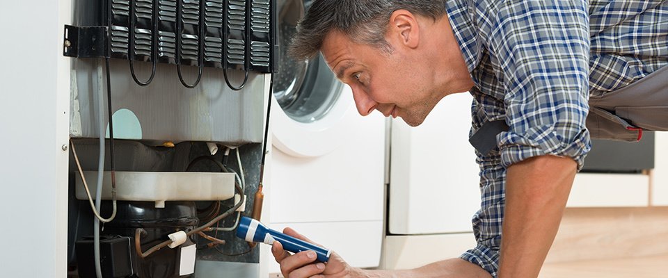 Technician repairing refrigerator